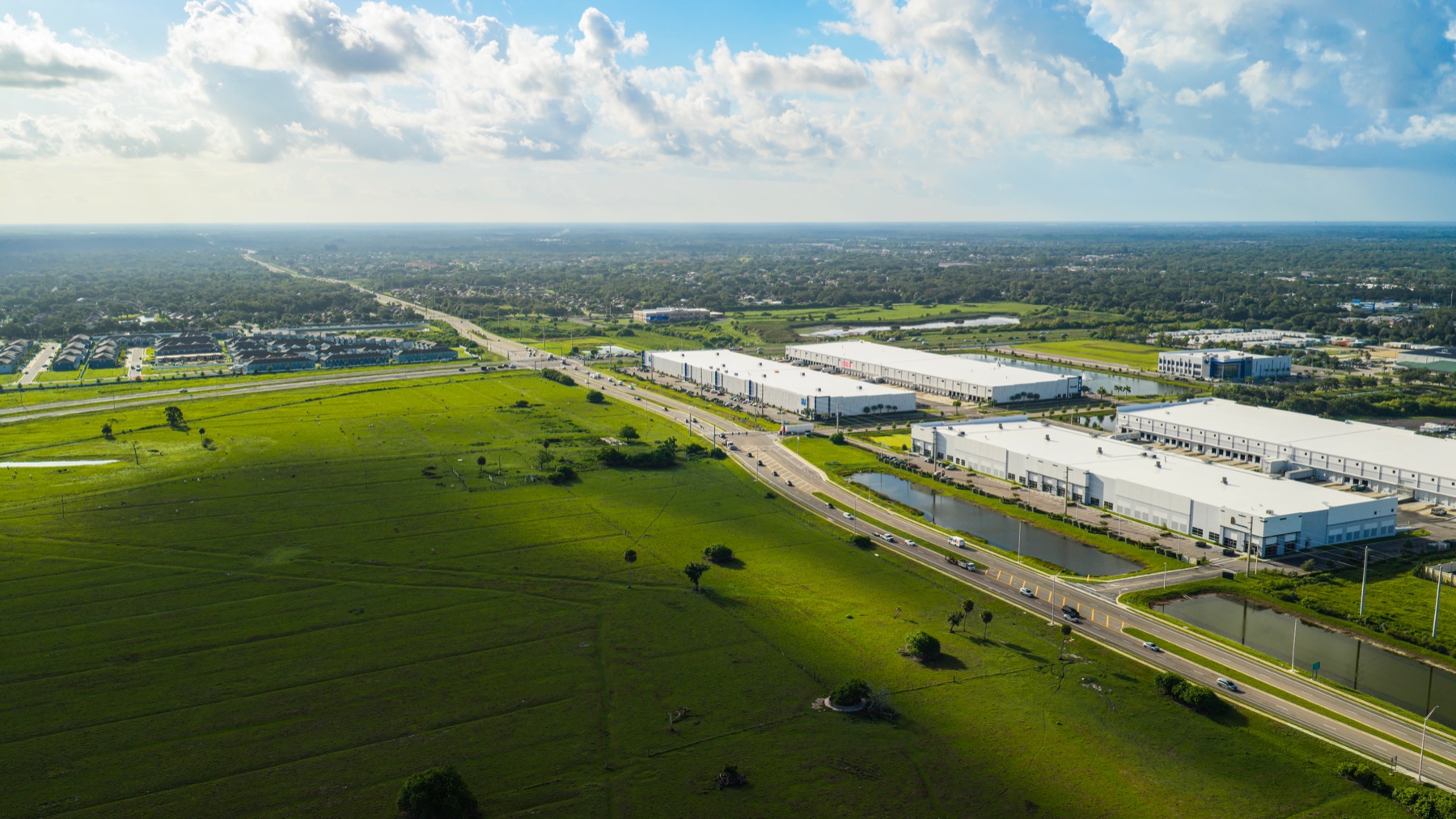 Aerial view of dense suburban development pressing against open pastoral land in Florida